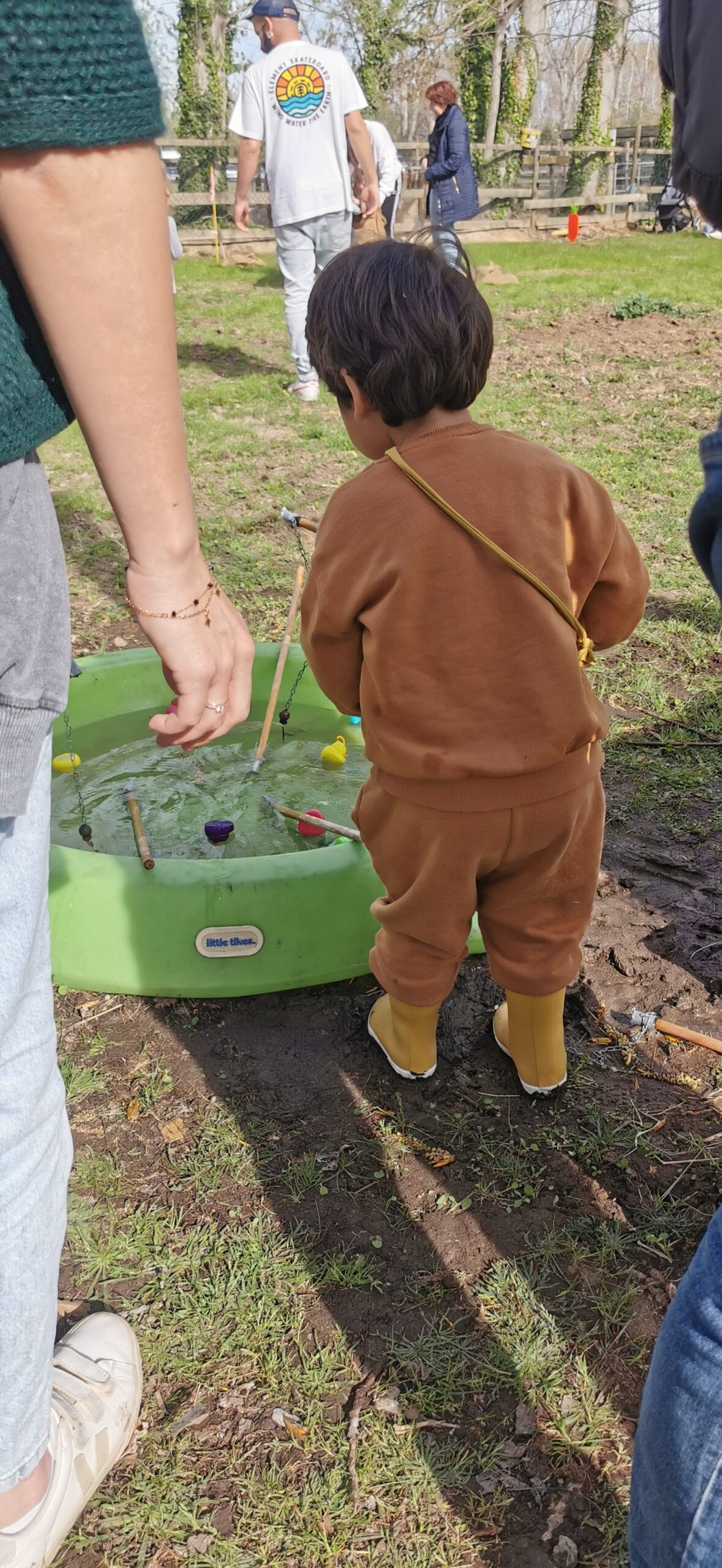 enfant avec bottes joue à la pêche au canard sur la ferme